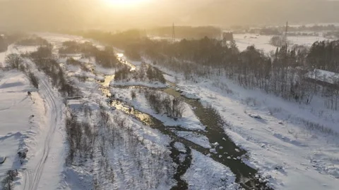 Flying above a bridge on winter river at sunrise, transportation in winter Stock Footage 231090949