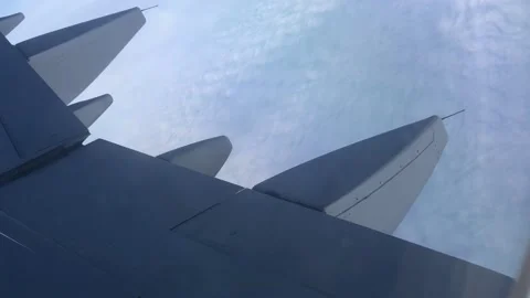Flying above the clouds on an airplane. View through the porthole on the wing Stock Footage 201153125