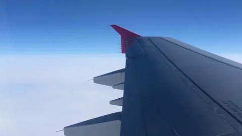 Flying above the clouds on an airplane. View through the porthole on the wing Vídeos de archivo 201153145