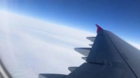 Flying above the clouds on an airplane. View through the porthole on the wing Video stock 203815440