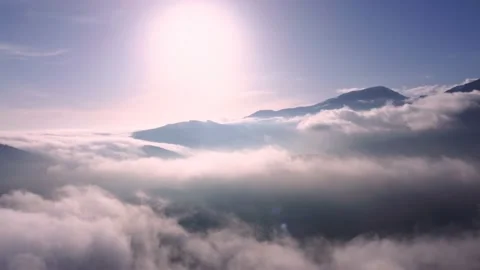 Flying above the clouds with blue sky and sun in front Stock Footage 234641132