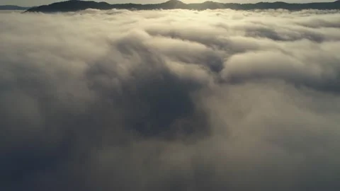 Flying above the clouds. Camera slowly tilts up from dense cloud surface to Stock Footage 139612664