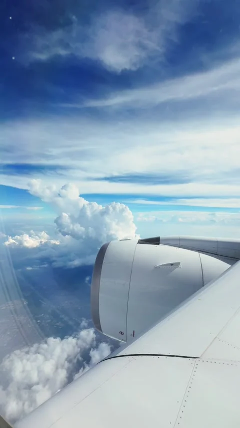 Flying above the clouds with a clear view from the airplane window on a sunny Video stock 305629198