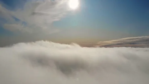 Flying above the clouds during sunset or sunrise Stock Footage 128989600