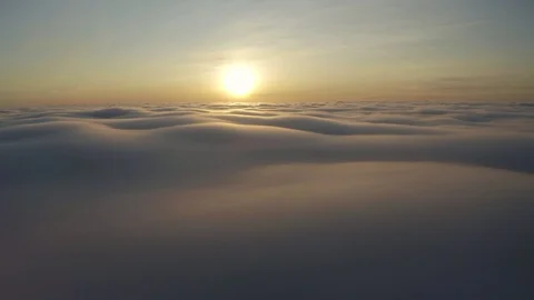 Flying above the clouds during sunset or sunrise Stock Footage 128989830