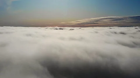 Flying above the clouds during sunset or sunrise Stock Footage 129099050