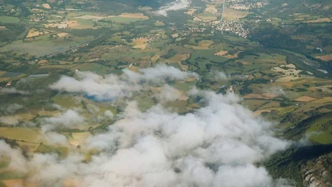 Flying above clouds, green fields. Cabin view from aeroplane. Aerial view. Stock Footage 125738240