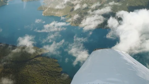 Flying above clouds, lake. Wing of private aeroplane. Alpine nature, mountains Video stock 125738063