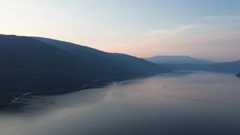 Flying Above the Clouds on a Mountain Lake at Sunrise Stock Footage 318817155