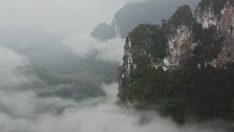 Flying above the clouds near the big green mountains during the rain in Thailand Stock Footage 201415010