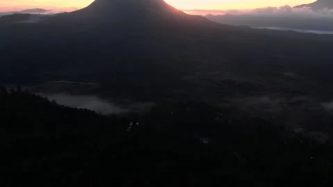 Flying above the clouds next to the volcano at sunrise Stock Footage 142986751