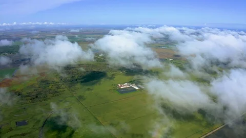 Flying above clouds passing over countryside patchwork farmland meadows. Stock Footage 116566659
