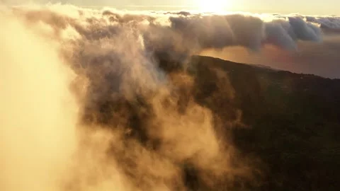 Flying above clouds at sunset in Madeira Portugal with the mountains and Stock Footage 322806013