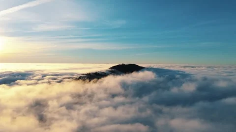 Flying above the clouds toward a mountain in time-lapse Video stock 319980734