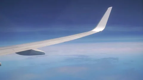 Flying above clouds with a view of the airplane wing in 4k Stock Footage 279236983