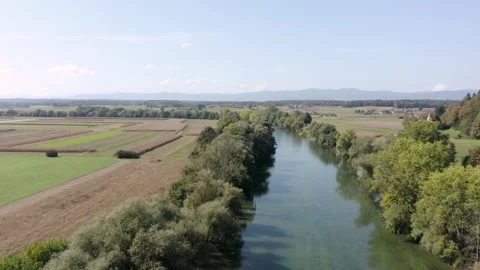 Flying Above crystal clear emerald river Kolpa flowing through green farmland Stock Footage 285771720