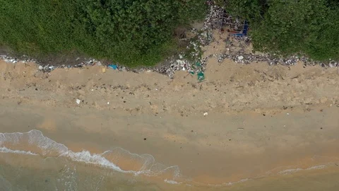 Flying above dirty polluted beach with lots of spreaded around polluted ocean cl Stock Footage 124602778
