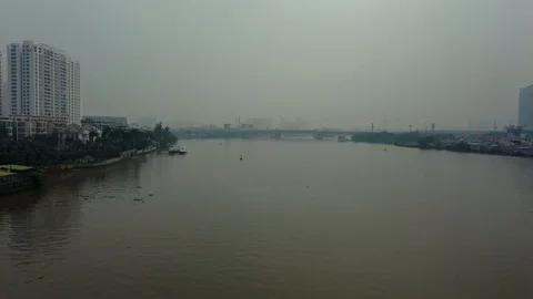 Flying above dirty polluted river in Saigon Vietnam Asia fog around city is in Stock Footage 124009796