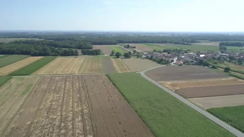 Flying above fields, town and passing by a small lake Stock Footage 148691299