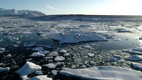 Flying above floating Icebergs. Ice from Glacier crystal shining on Sunset. Ice Stock Footage 108545890