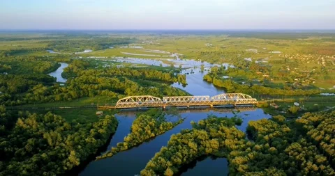 Flying above freight train on the railway bridge, flood-meadow and river. Stock Footage 105980123