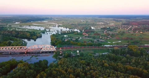 Flying above freight train on the railway bridge, flood-meadow and river Stock Footage 106068125