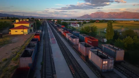 Flying Above Freight Train Toward River and Farmland at Golden Sunset Stock Footage 340500870