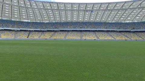 Flying above grass on a small height inside huge modern empty stadium. 4K Video stock 63856531
