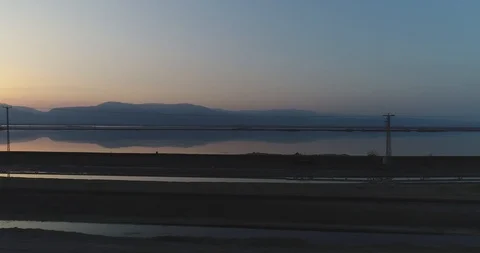 Flying above the ground next to the Dead Sea during sunrise 4K Stock Footage 106339715