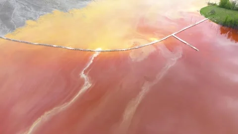Flying above orange water mining residual water pattern decanting lake, aerial Video stock 300538181