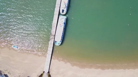 Flying above the pier, over a reef and blue ocean Aerial view of beautiful beach 스톡 동영상 74649686