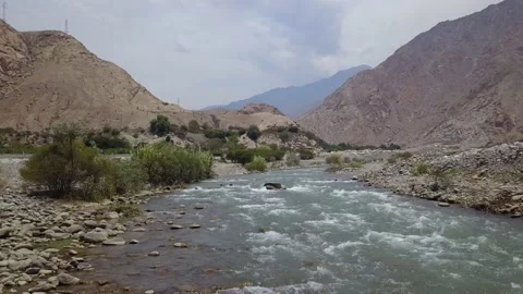 Flying above a river with a drone with a view of mountains and trees Video stock 144686852