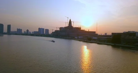 Flying above river under clear blue sky towards boat in sunrise in Bangkok Stock Footage 108573852