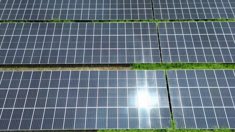 Flying above rows of solar panels generating green energy for sustainable future Stock Footage 306971140