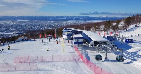 Flying above ski resort "Mountain air", ski elevator, tourists and the cityscape Stock Footage 88486512