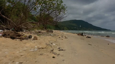 Flying above spreaded garbage and trash with plastic on a sand beach shore in Vi Stock Footage 124602899