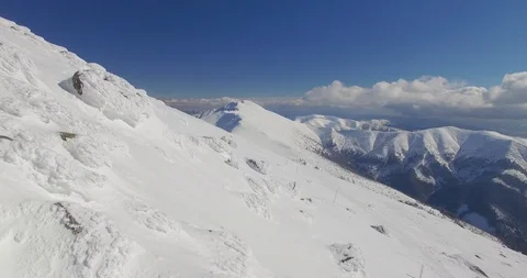 Flying above top of the mountain in snow winter. Nice sunny day,beautiful clouds Stock Footage 85882438
