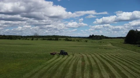 Flying above a tractor and over a green field Stock Footage 158757626