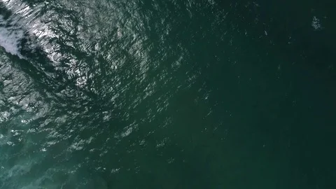 Flying above the waves, camera panning up from the sea to reveal rocky cliffs 스톡 동영상 77505676
