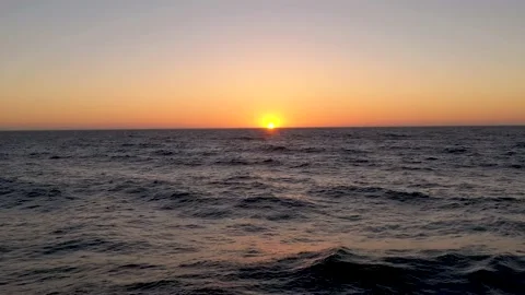 Flying above waves in the sea while the sun is setting below the horizon. Stock Footage 218350599