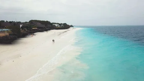 Flying above white sand and azure ocean of wide paradise beach on cloudy day. Stock Footage 91801862