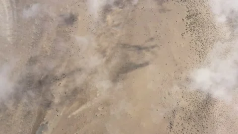 Flying above white thin clouds leaving a shadow behind on the land Stock Footage 142751888