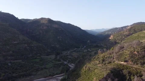Flying Above Winding River Between Hills With Sun Creating Shadows Video stock 255705571
