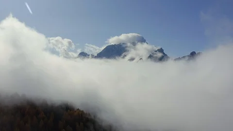 Flying above a wood covered by clouds and the Civetta mountain range, Dolomites Stock-Footage 129806085
