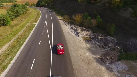 Flying above young couple driving the luxury red convertible car. Happy couple. Stock Footage 202219458