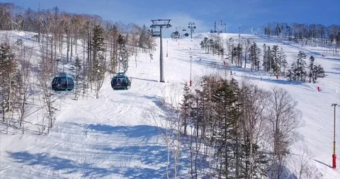 Flying abve the ski slope of ski resort and aerial view of ski lift elevator Stock Footage 88485916