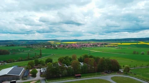 Flying across the field to a small town in bad weather Stock Footage 154371714