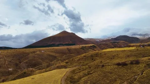 Flying against the mountains and fields in cloudy weather Stock Footage 293698239
