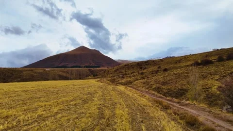 Flying against the mountains and fields in cloudy weather Stock Footage 293698669