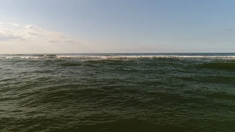 Flying against the waves rolling on to shore - Aerial Stock-Footage 103354168
